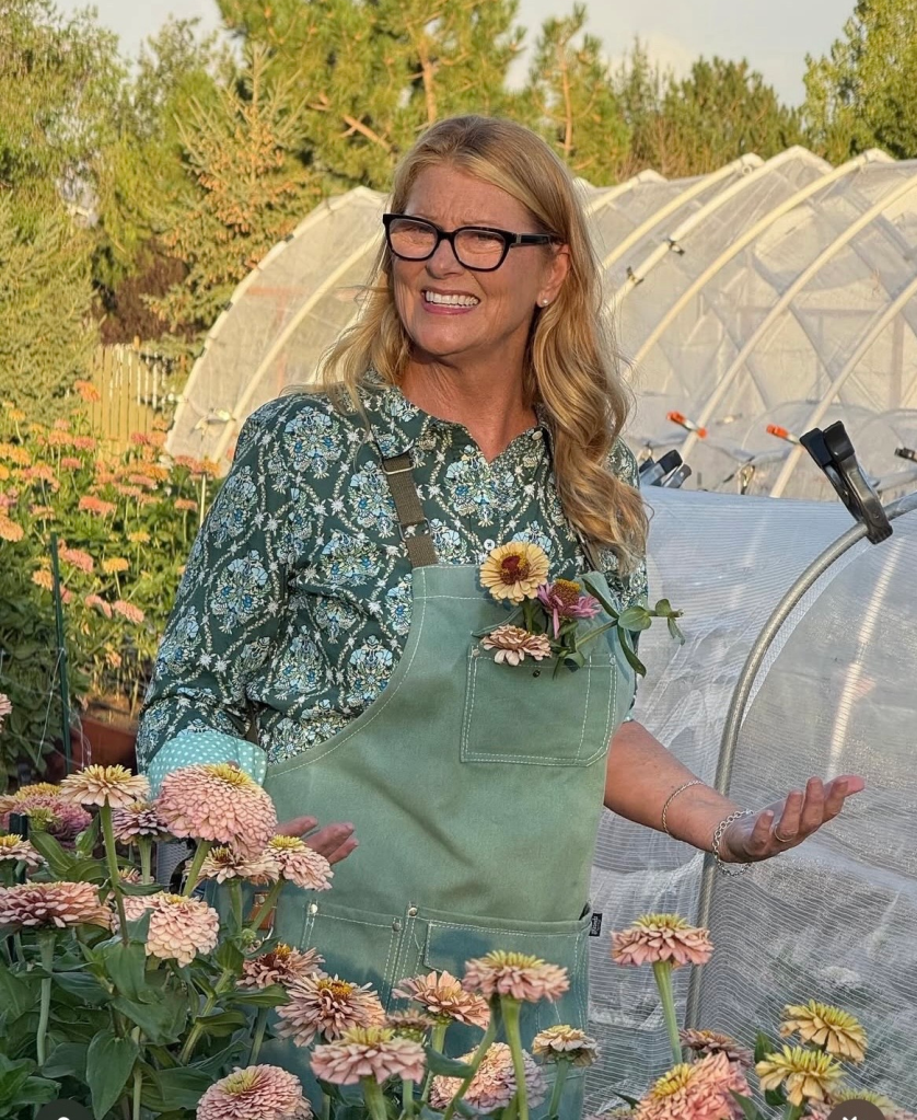 Zinnia Breeder Tiffany Jones in a bed of pastel pink zinnias